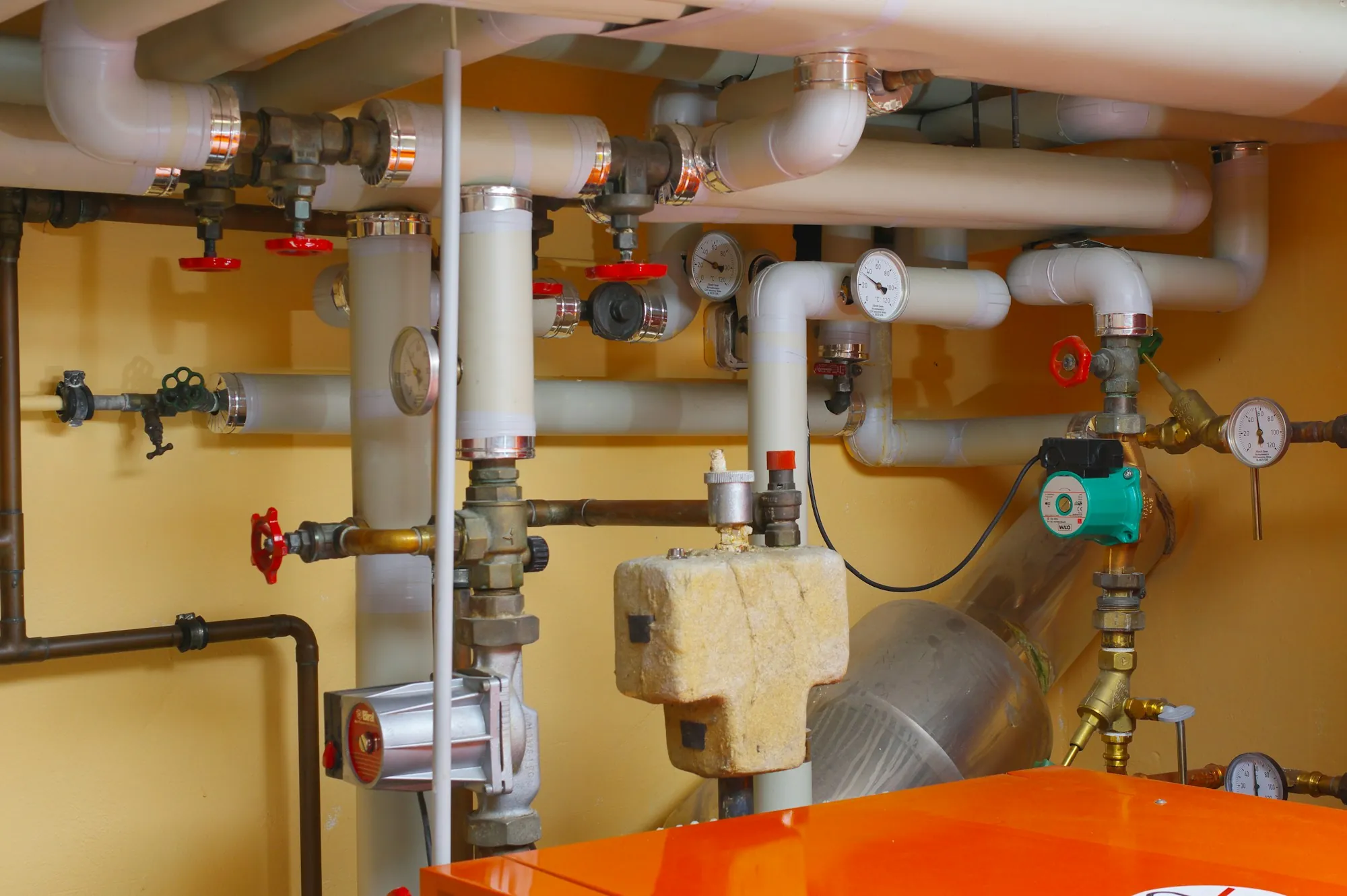 Whole-House Water Filtration in Fountain Valley, CA Water pipes, valves and pressure gauges in a utility room