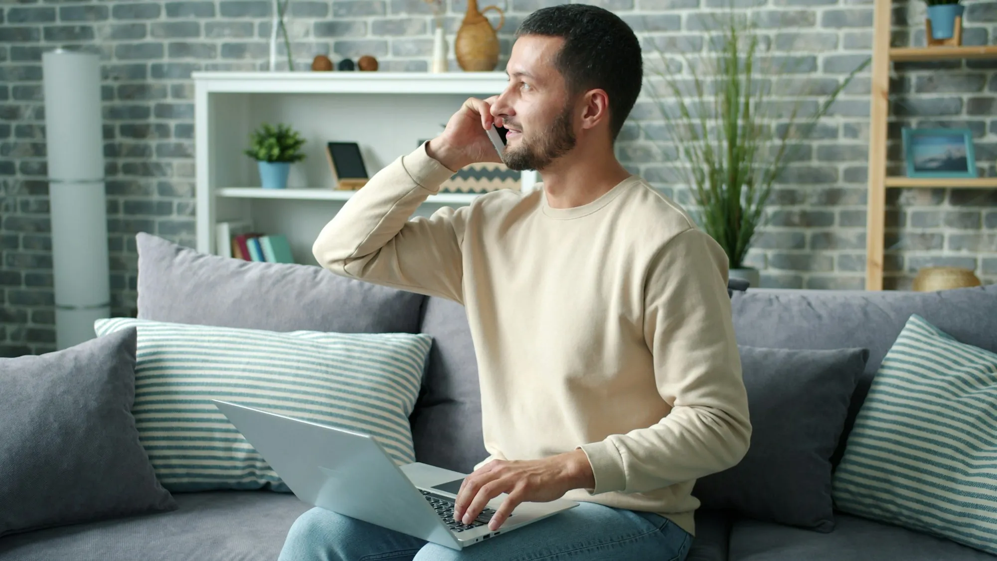 Contact Fountain Valley Water Pros Homeowner on a phone call with a laptop on the sofa