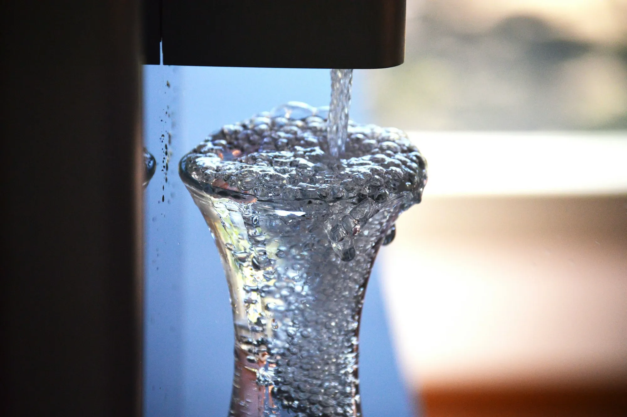 Water pouring into a clear glass