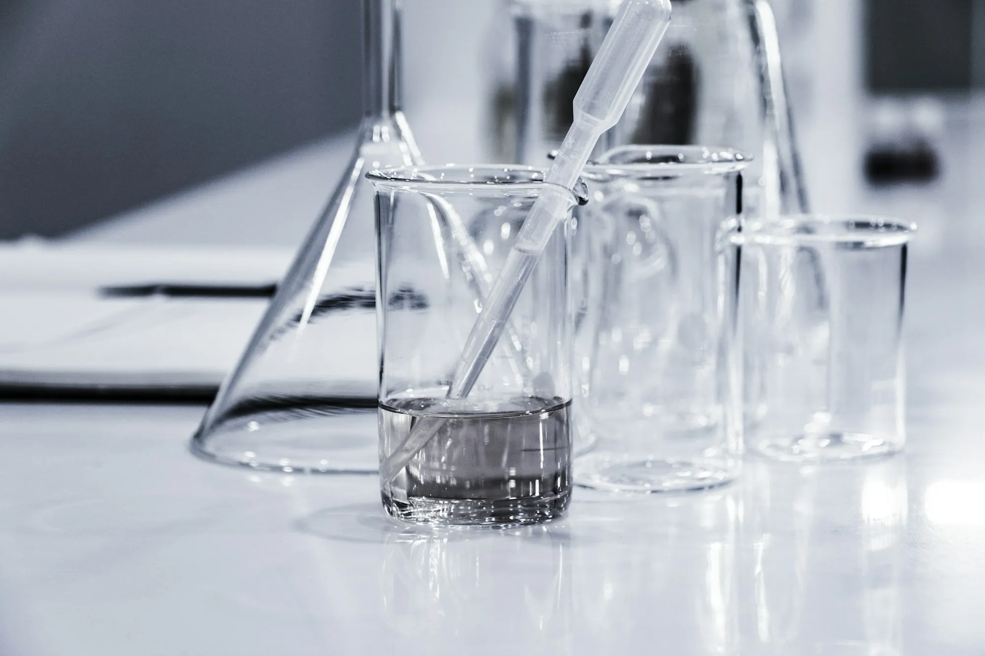 Water Testing & Analysis in Fountain Valley, CA Water sample in clear beakers with a pipette on a lab bench